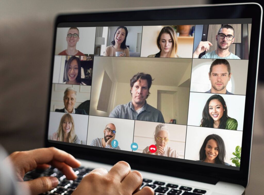 A person on a laptop participating in a diverse virtual meeting with nine other individuals on screen.