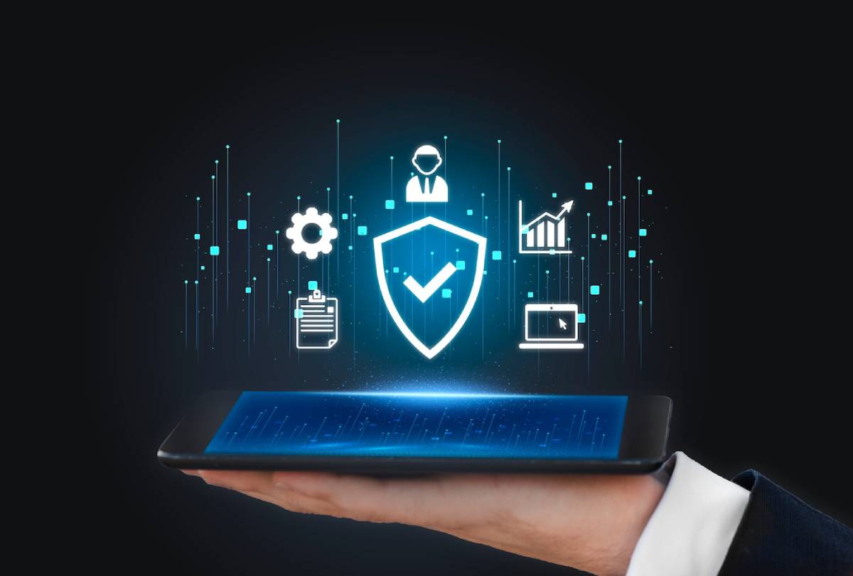  A hand holding a tablet displaying futuristic digital security and data management icons on a dark background.