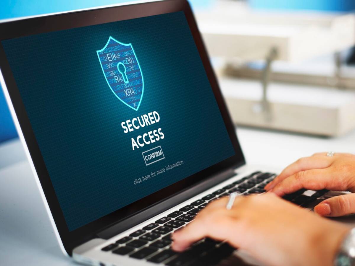 Person using a laptop displaying a Secured Access confirmation screen in an office setting. 
