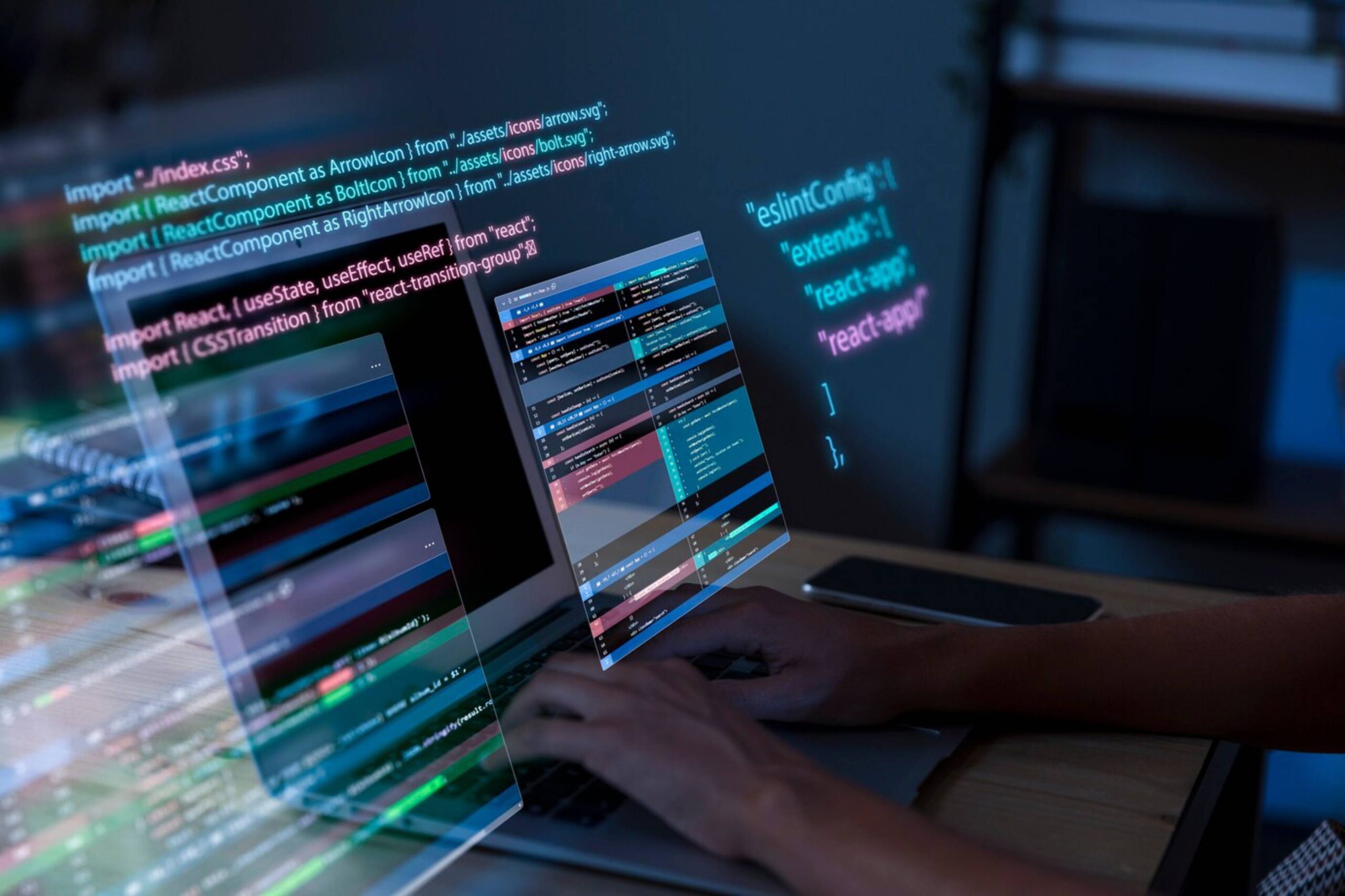 Person coding on a laptop with code projected on screens, highlighting web development work in a dark room. 