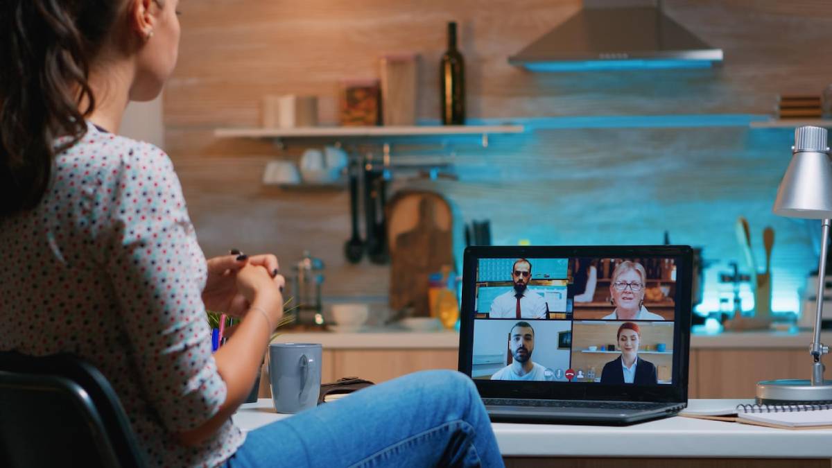 A woman participates in a video conference call from her kitchen. 